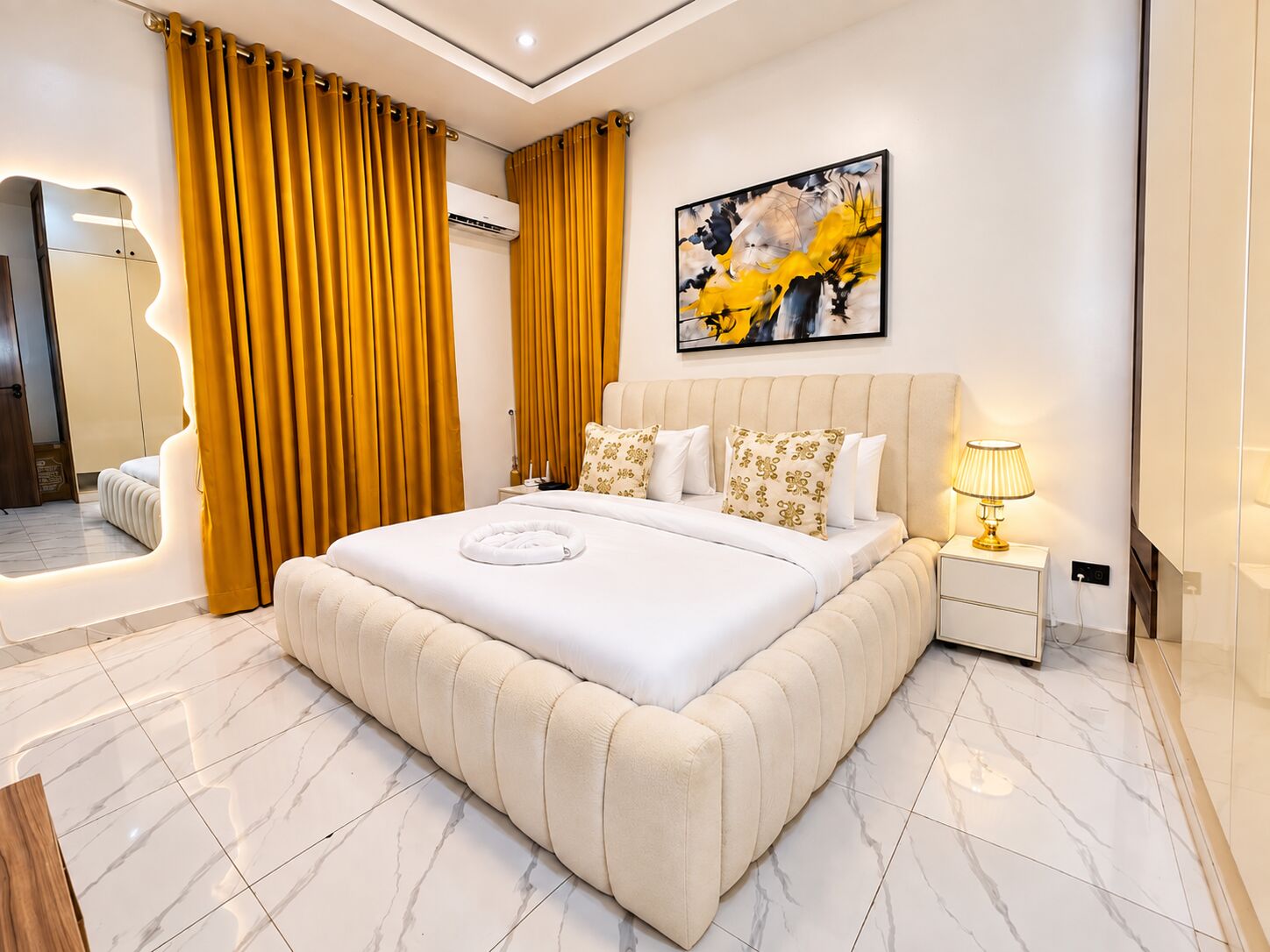 Deluxe Room with upholstered bed, gold drapes and marble floor