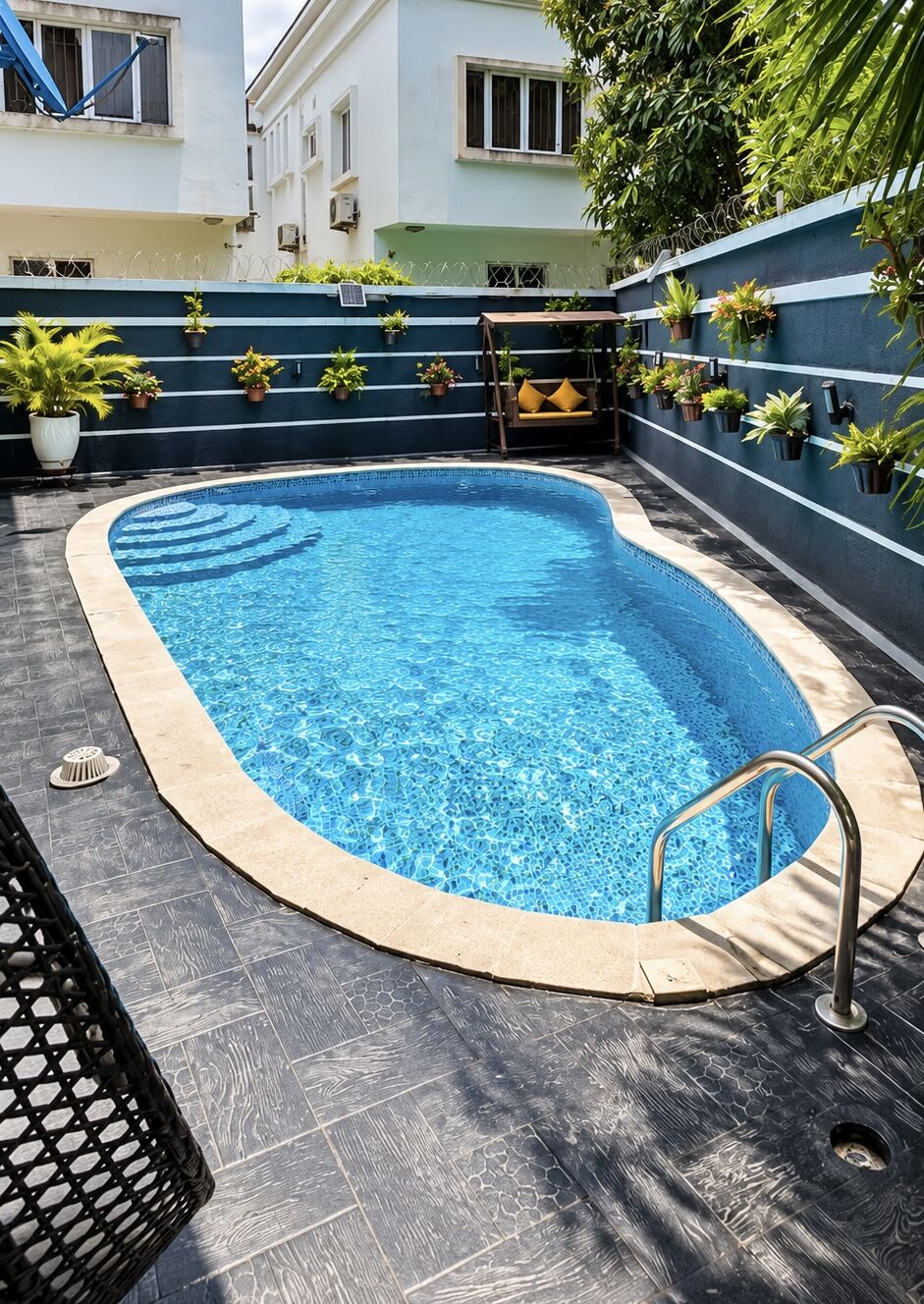 The pool on a bright day, framed by planted walls