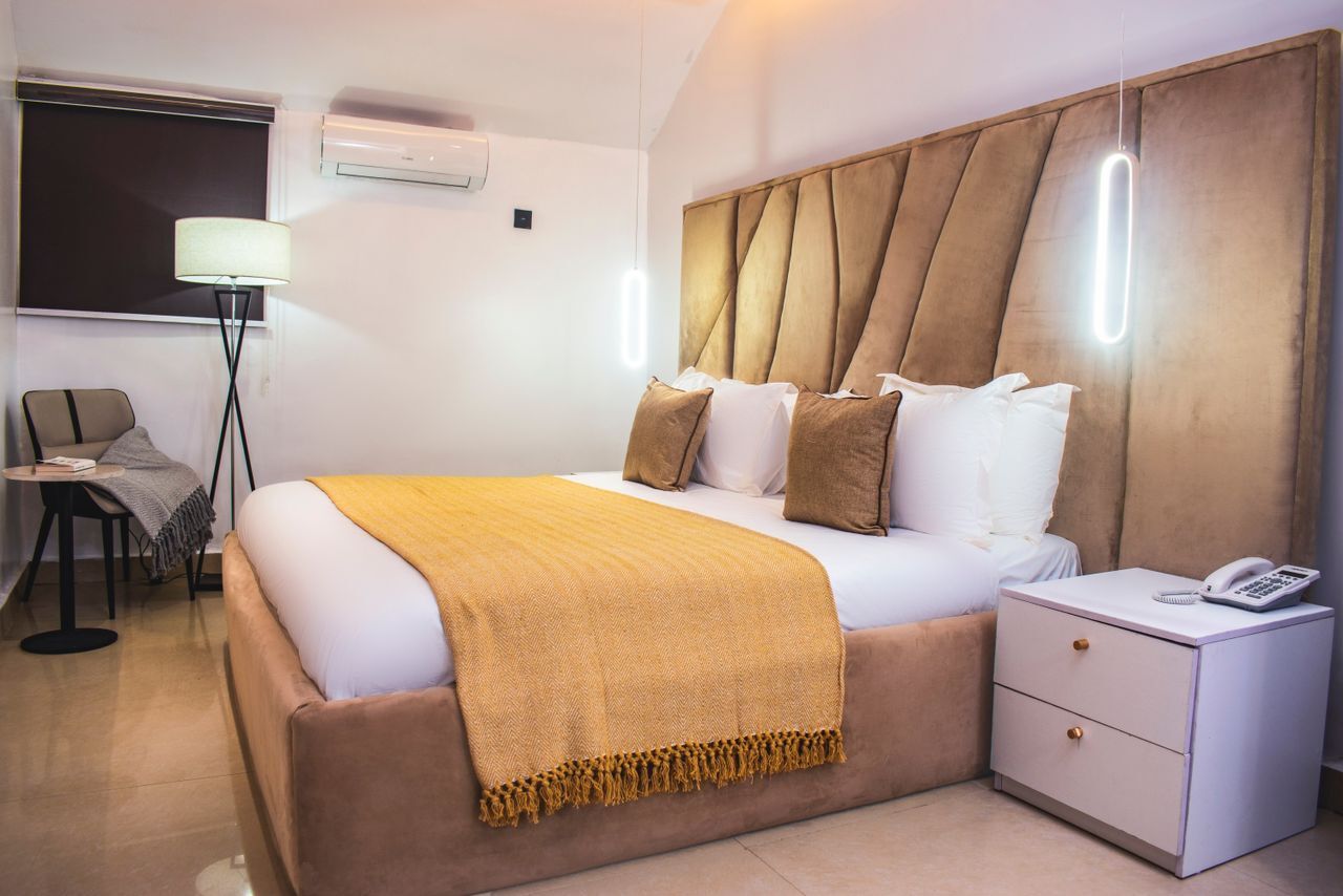 Deluxe room with sculpted headboard and gold throw